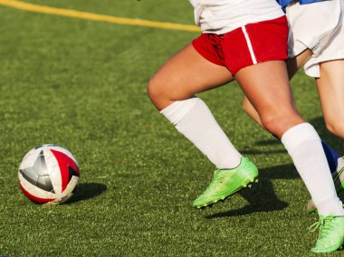 İki kadın lise futbol oyuncu topu kovalarken