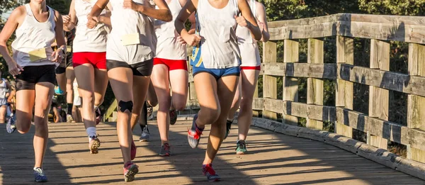 High school cross country girls corrida sobre uma ponte — Fotografia de Stock