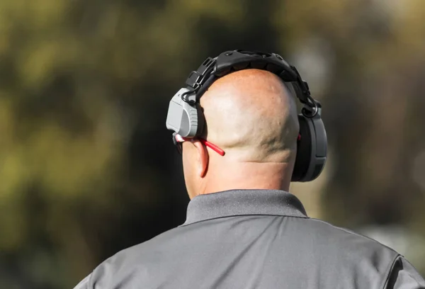 Football coaches head from behind as he looks downfield