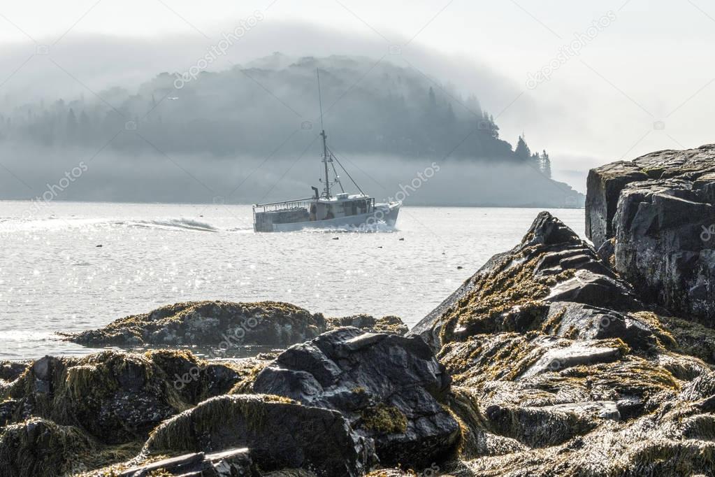 Lobster boat heads out of Bar Harbor on a foggy morning in Maine