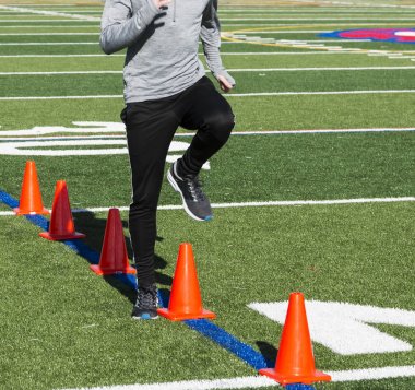 Hız matkaplar üzerinde turuncu konileri çim sahada çalışan.