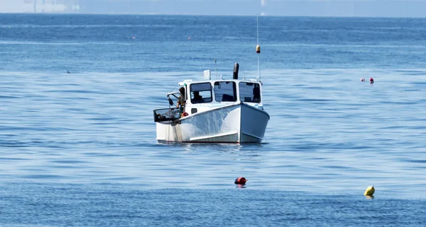 Barco de pesca puxa armadilhas de lagosta em barco — Fotografia de Stock