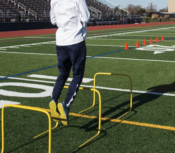 Saltando sobre barreiras amarelas durante o treinamento de velocidade — Fotografia de Stock