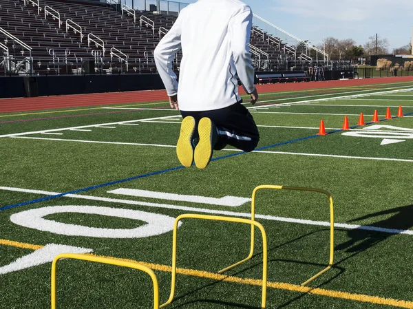 Atleta salta sobre los obstáculos amarillos haciéndolo parecer fácil — Foto de Stock