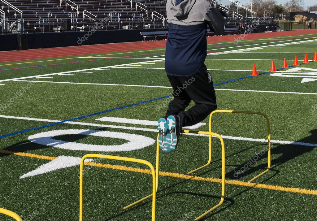 Jumping over hurdles for strength and coordination training — Stock Photo © WoodysPhotos 180395760