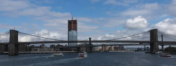 Линия круга и другие туристические лодки направляются под Бруклин-Брид — стоковое фото