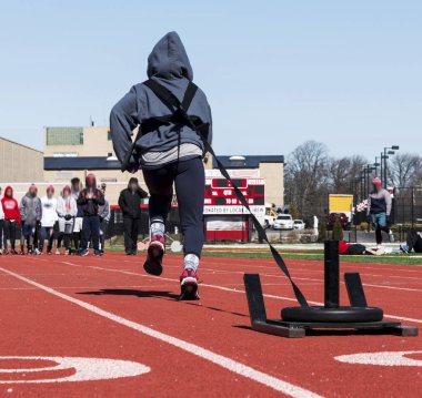 Bir parça ağırlıkları ile bir kızak çekme atlet