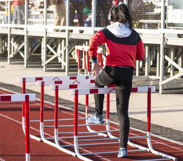 Hurdler haciendo ejercicios de obstáculos antes de una carrera — Foto de Stock