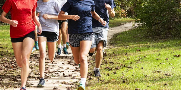 Grupo de corredores correndo rápido em um caminho de terra em um parque — Fotografia de Stock