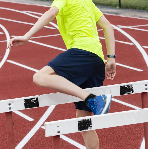 Atleta realizando obstáculo andar sobre brocas em uma pista — Fotografia de Stock