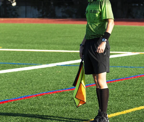 Soccer linesman official on the sideline holding a flag — Stock Photo, Image