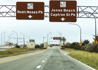 Driving on Robert Moses Causeway toward draw bridge with street  clipart