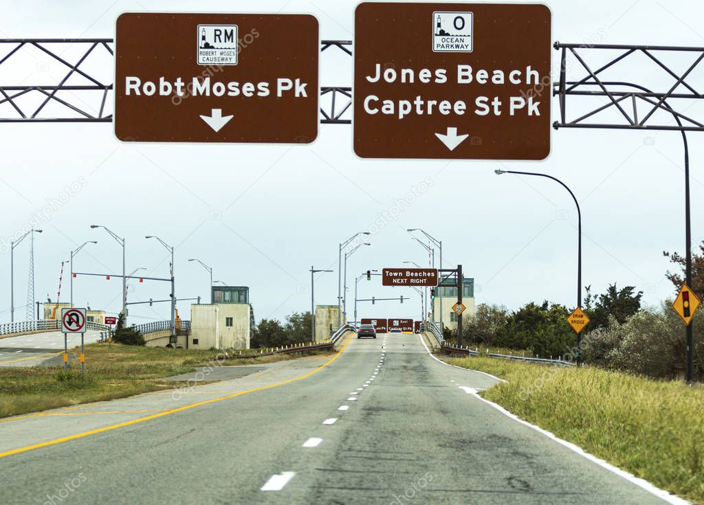 Driving on Robert Moses Causeway toward draw bridge with street 