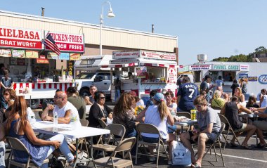 Müşteriler masalarında oturup yerel Fa 'da yemek kamyonunun tadını çıkarıyorlar.