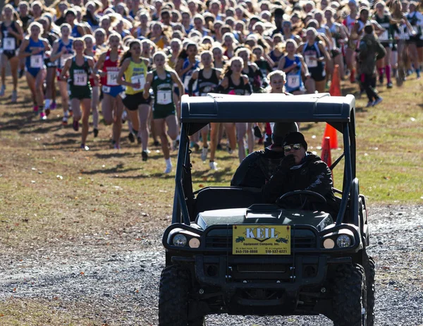 Lopers volgen kar aan het begin van een meisjes cross country rac — Stockfoto