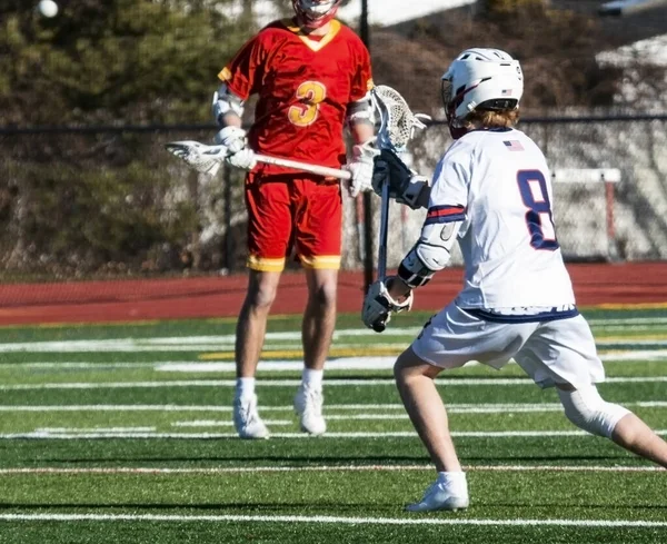 Meninos jogando no jogo de lacrosse do ensino médio — Fotografia de Stock