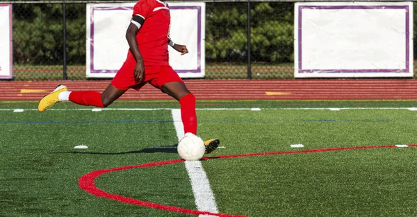 Soccer player in red uniform about to kick the ball — Stock Photo, Image