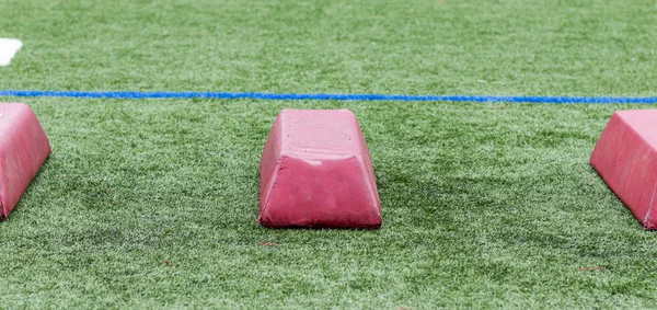 Három piros gyakorlati akadályok a sportolók, hogy elkerüljék a gyeppályán — Stock Fotó