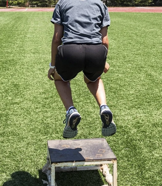 Vista posteriore dell'atleta che salta su una scatola di plyo — Foto Stock