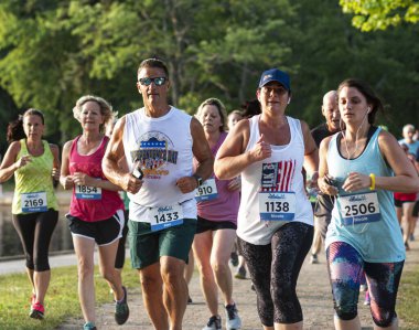 Kuzey Babylon, New York, ABD - 8 Temmuz 2019: Yıllık State Park yaz serisi yarışları sırasında Belmont Gölü Parkı 'nda 5K koşan çok sayıda koşucu.
