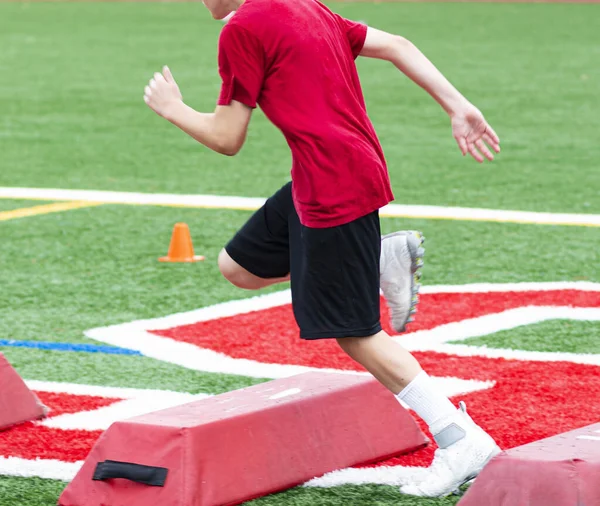 Jovem Adolescente Está Correndo Sobre Barreiras Vermelhas Colocadas Campo Relva — Fotografia de Stock