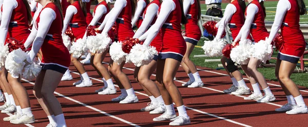 サッカーの試合中に群衆のために実行赤と白の制服を着た高校のチアリーディング — ストック写真