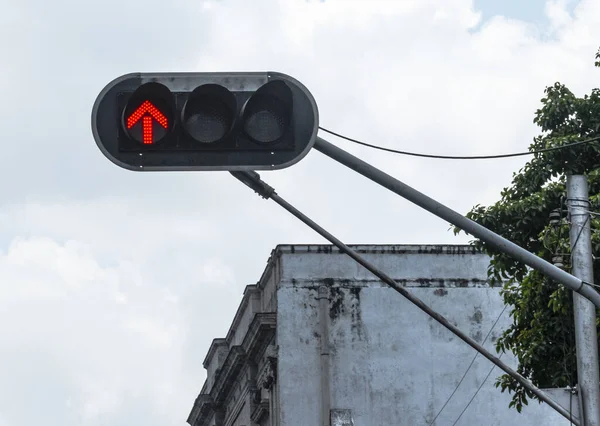 A traffic light signal is displayed as a red arrow on a stoplight in Havana Cuba.