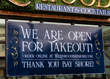 Bay Shore, New York, ABD - 18 Nisan 2020: Sadece paket servis için açık olduğumuz bir restoranın vitrininde büyük bir tabela asılı ve COVID-19 Coronavirus pandemisi sırasında teşekkür ederiz.