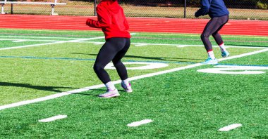 İki genç lise sporcusu spor antrenmanı sırasında Kereoke sahasında antrenman yapıyorlar..