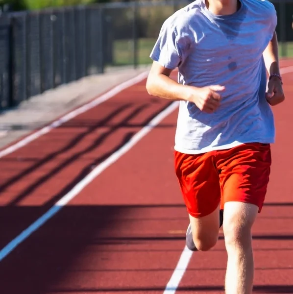 Передній Вигляд Бігуна Середньої Школи Біжить Червоній Доріжці Його Тренувальній — стокове фото