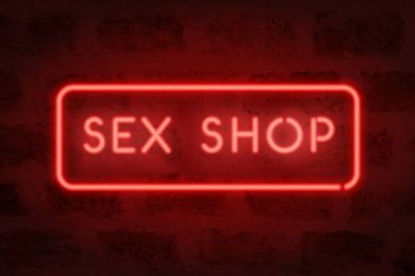 Seks shop neon. Kırmızı işaret üstünde belgili tanımlık duvar. Yetişkin mağaza