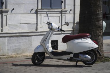 Izmir, Türkiye - 5 Haziran 2017: Yeni bir beyaz Vespa Scooter Izmir, Alsancak eski bir taş bina önünde park yapıldı..