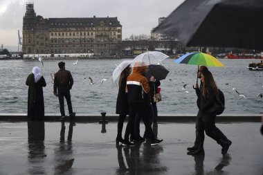İstanbul, Türkiye-8 Mart 2018: Istanbul 'da yağmurlu bir gün, Kadiköy Sahili. Bazı insanlar şemsiyeler ile yürüyor, arabalar Haydarpaşa Tren İstasyonu manzara izliyor.