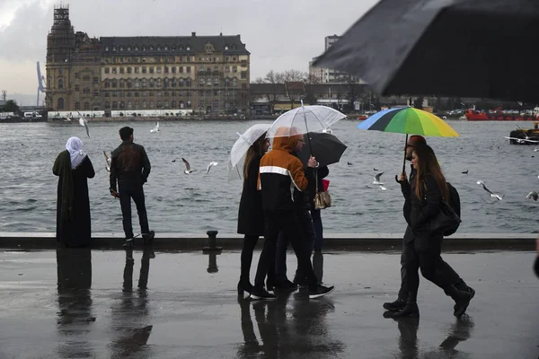 İstanbul, Türkiye-8 Mart 2018: Istanbul 'da yağmurlu bir gün, Kadiköy Sahili. Bazı insanlar şemsiyeler ile yürüyor, arabalar Haydarpaşa Tren İstasyonu manzara izliyor.