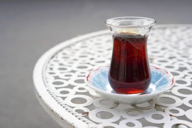 Caddedeki metal bir kafe masasında Türk çay bardağında çay servisi yaptım..