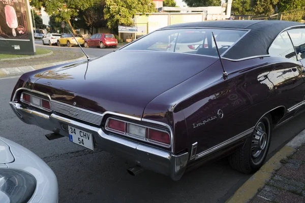Вид сзади на фиолетовый Chevrolet Impala купе был припаркован на улице — стоковое фото