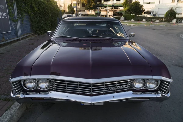 Vista frontal de um Chevrolet Impala coupe roxo foi estacionado em uma rua — Fotografia de Stock