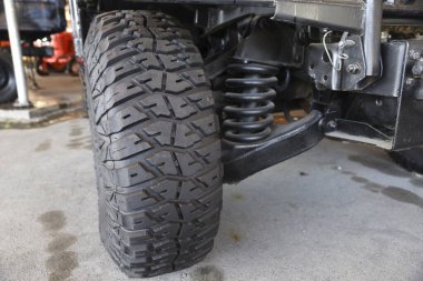 Close-up new military jeep tire and car suspension of an vintage jeep at outdoor clipart