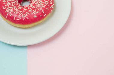 Lezzetli lezzetli sırlı parlak pembe çörek üzerinde mavi ve pembe backgr