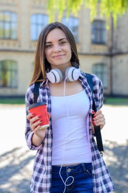 Mutlu genç kız kot pantolon ve backp ile damalı gömlek gülümseyen