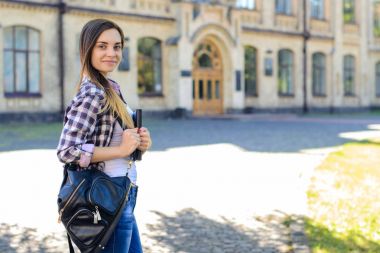 Genç oldukça gülümseyen kız öğrenci backp ile rahat kıyafetler içinde