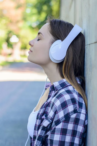 Joven dama encantadora en auriculares escuchando a su mu favorito — Foto de Stock