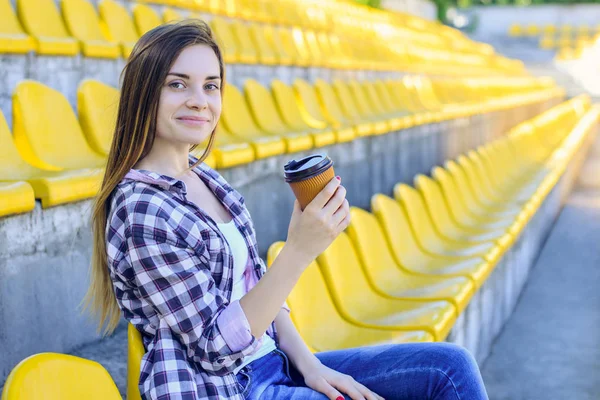 Sonriendo feliz mujer bebiendo café y viendo el partido en th — Foto de Stock
