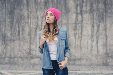 Gülümseyen güzel hipster kadın rahat giyim, pembe şapka, kot pantolon