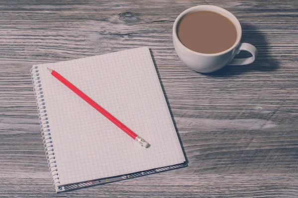 Arka plan açık defter, kalem ve sıcak kahve masada, üstten görünüm. İlham için bekliyor
