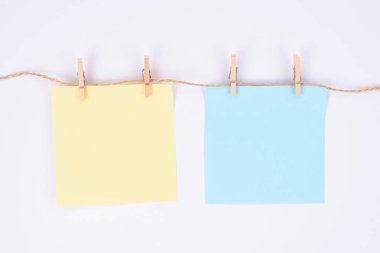 İki kare kağıt çarşafın fotoğrafı izole edilmiş beyaz ipte asılı. 