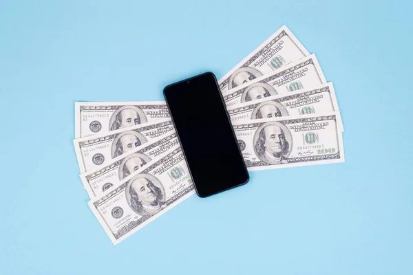 Easy and quick money send concept. Top above flat lay close up view photo of smart phone with money wings isolated pastel color blue background