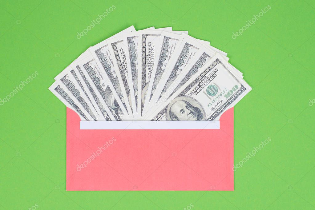 Getting credit deposit money from bank concept. Top above close up view photo of red envelope full of money isolated over bright green background