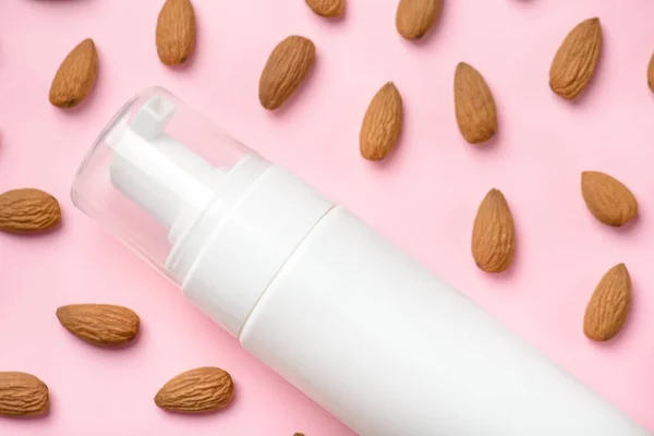 B vitamins in balm for body for good hydration concept. Cropped close up top overhead view photo of bottle with facial foam and almond nuts isolated over colorful background