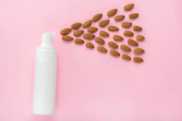 Organic natural spray concept. Top above overhead view photo of lotion bottle spreading almond like drops to the side isolated pastel color background with copy empty blank space